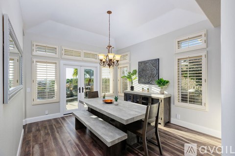 A dining room with a table and chairs and a chandelier.