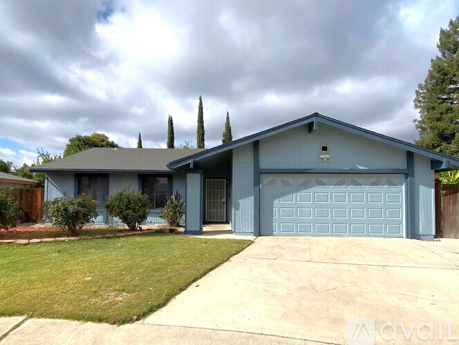 A two-story house with a garage door and a driveway.