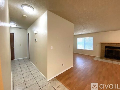 A living room with a fireplace and a tiled floor.