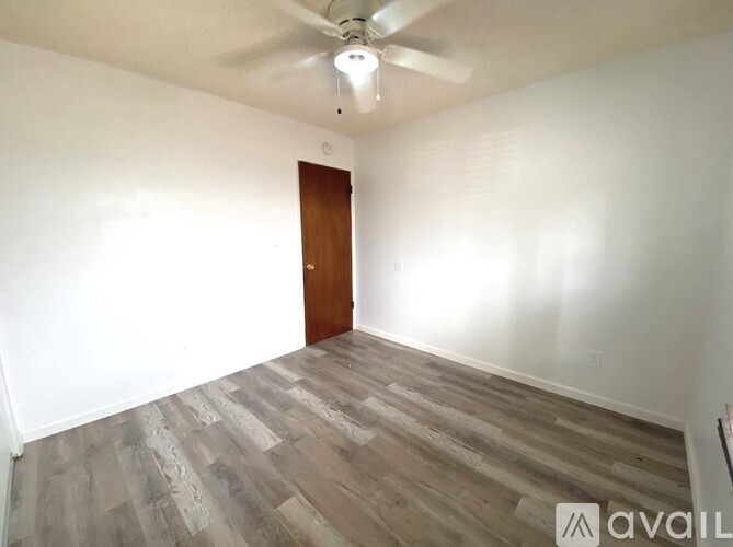 A room with a wooden door and a ceiling fan.