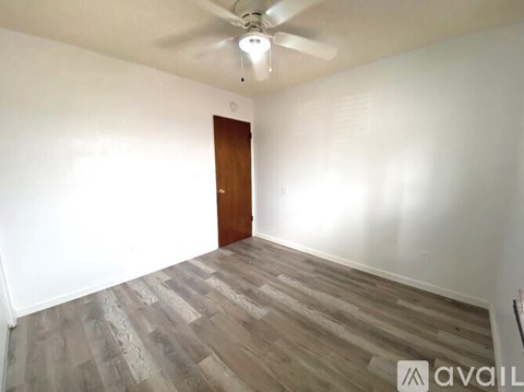 A room with a wooden door and a ceiling fan.
