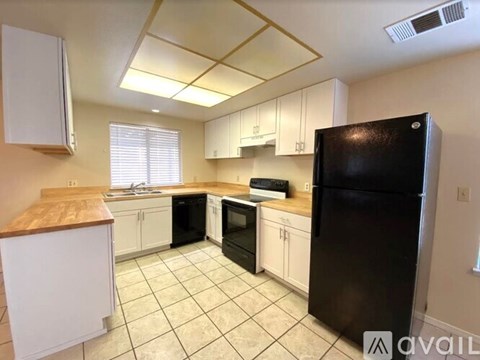 A kitchen with black appliances and white cabinets.