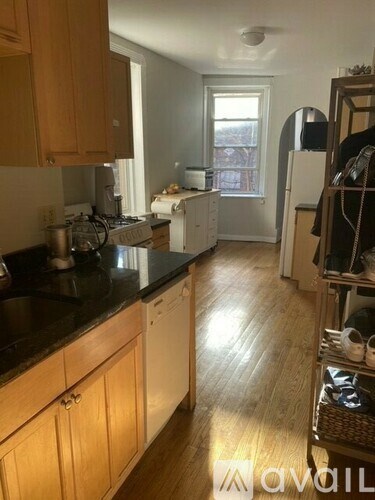 A kitchen with wooden cabinets and a black countertop.