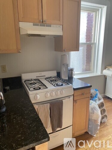 A kitchen with a white stove and wooden cabinets.