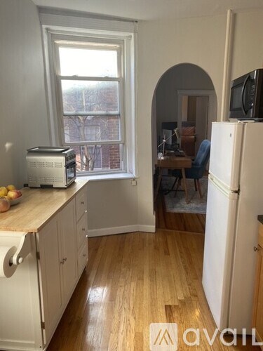 A kitchen with a refrigerator, toaster, and a window.