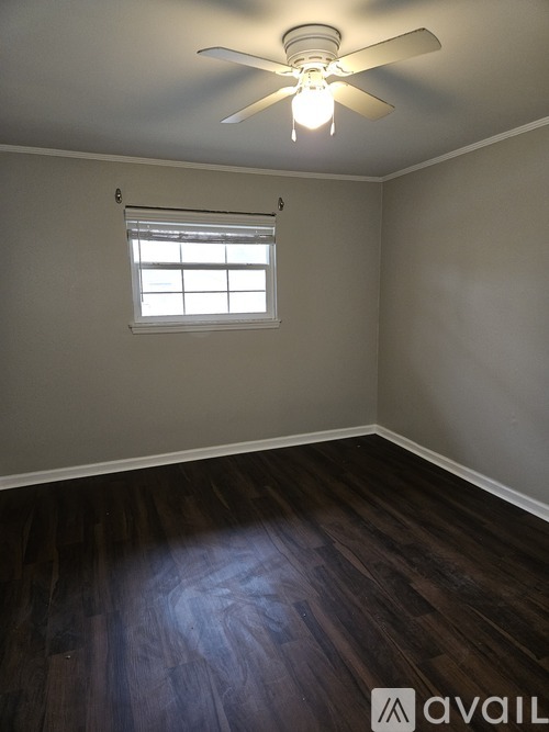 A room with a ceiling fan and a window.