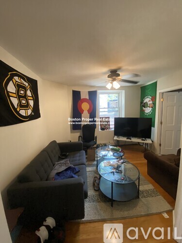 A living room with a Boston Bruins logo on the wall.