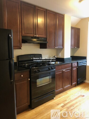 A kitchen with wooden cabinets and black appliances.
