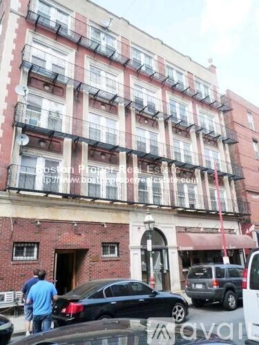A red brick building with a balcony on the second floor.
