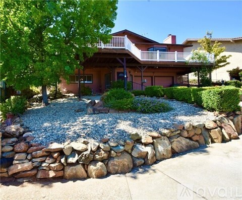 A house with a stone wall in front.