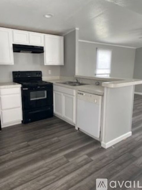 A kitchen with white cabinets and a black stove top oven.