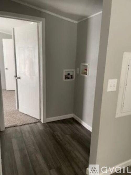 A hallway with a white door and a carpet on the floor.