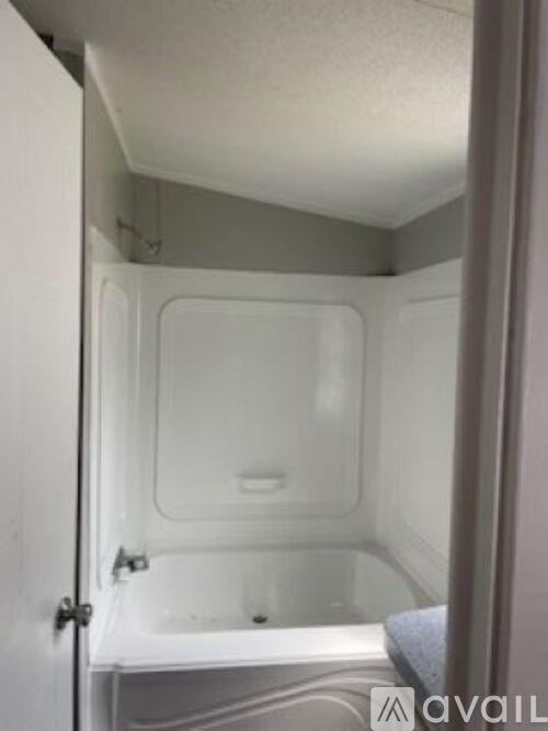 A small white bathroom with a toilet and a bathtub.