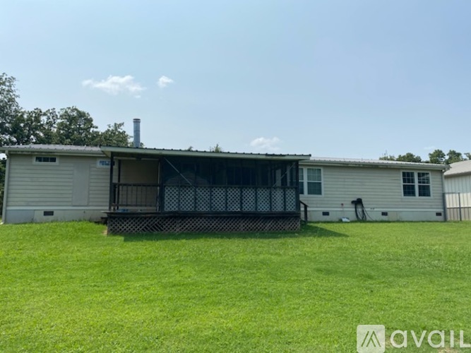A house with a white exterior and a black fence is available for rent.