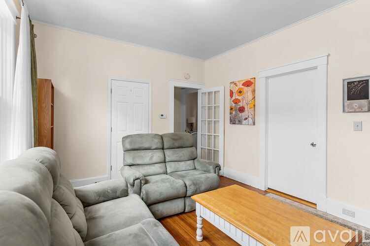 A living room with a grey recliner and a wooden coffee table.