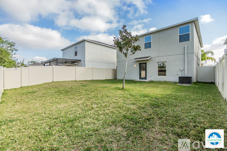 A modern house with a white exterior and a large yard.