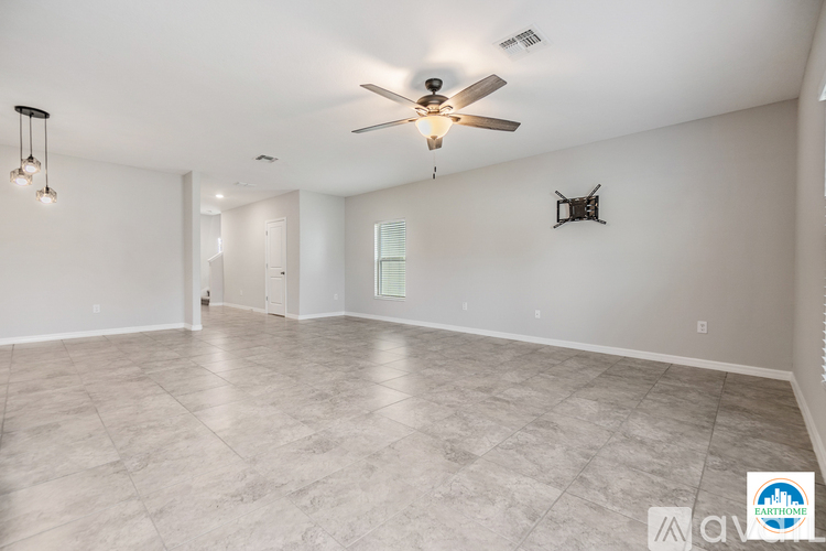 A spacious room with a ceiling fan and lighting fixtures.
