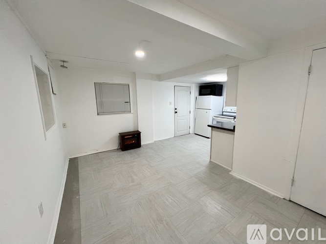A spacious room with a grey floor and white walls.