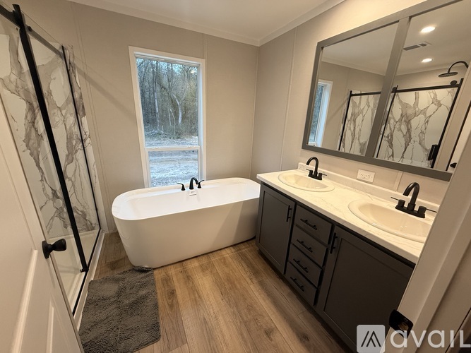 A bathroom with a white tub, sink, and mirror.
