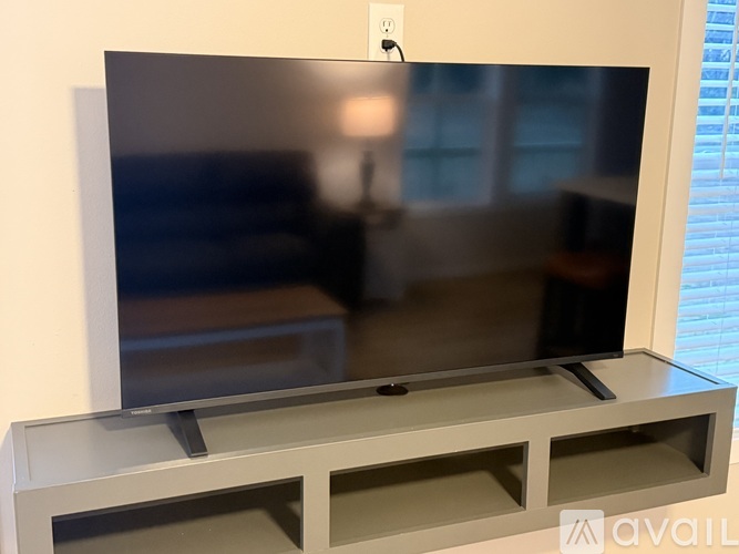 A flat screen TV mounted on a wall with a remote control.