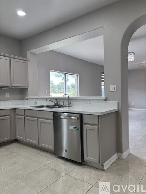 A kitchen with a sink and a trash can.