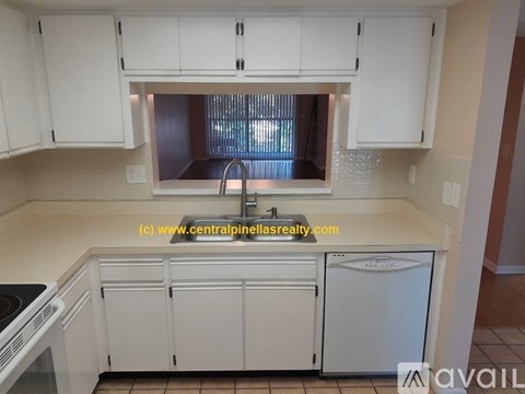 A kitchen with white cabinets and a stove top oven.