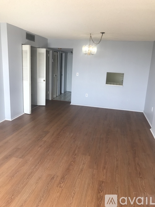 A room with wooden floors and a chandelier.