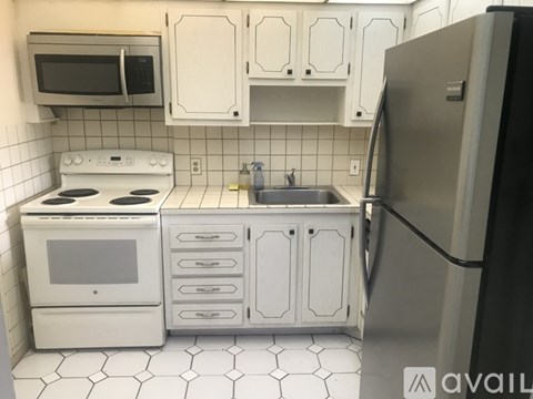 A kitchen with white appliances and cabinets.
