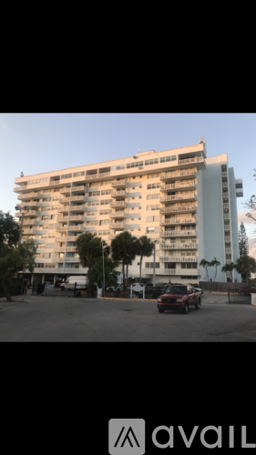 A tall building with a red car parked in front of it.