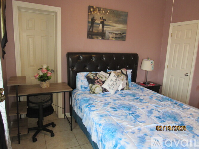 A bedroom with a bed, desk, and chair.