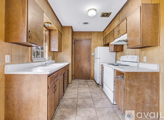 A kitchen with wooden cabinets and white appliances.