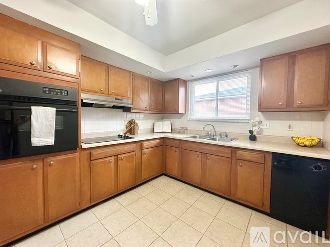 A kitchen with wooden cabinets and black appliances.