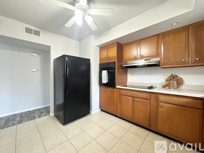 A kitchen with black appliances and wooden cabinets.