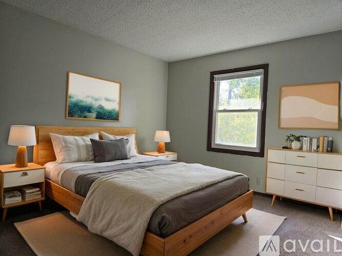 A bedroom with a bed, nightstands, and a window.