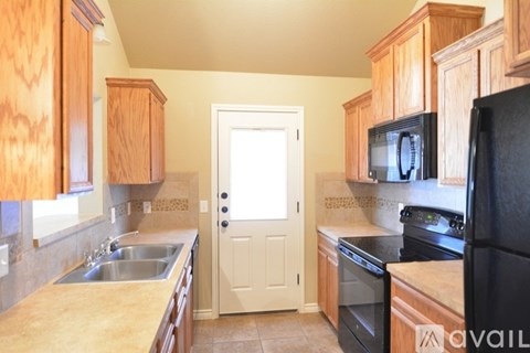 A kitchen with wooden cabinets and black appliances.