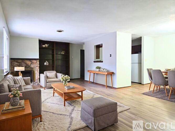 A living room with a grey couch, a coffee table, and a fireplace.