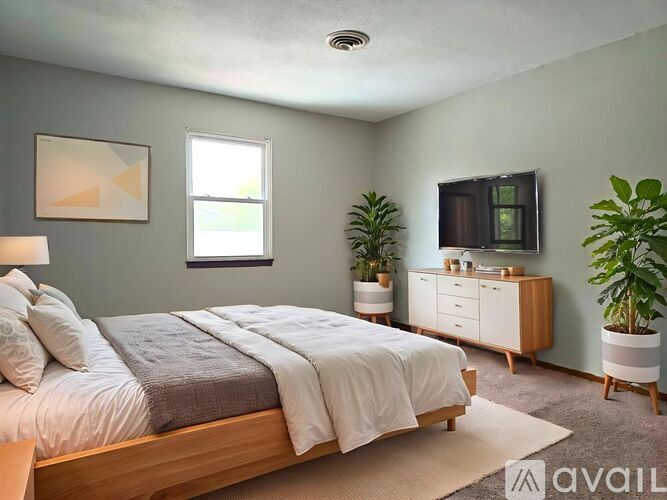 A bedroom with a bed, a dresser, and a window.