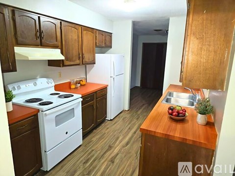 A kitchen with wooden cabinets and a white stove top oven.