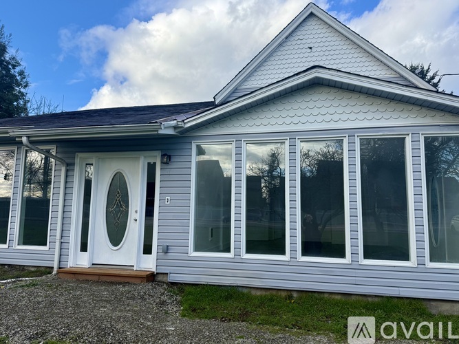 A house with a white door and windows is for sale.
