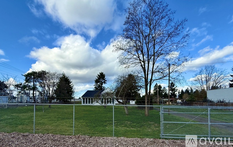 A fenced field with a house in the background.
