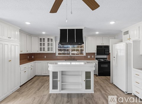 A modern kitchen with white cabinets and a wooden countertop.