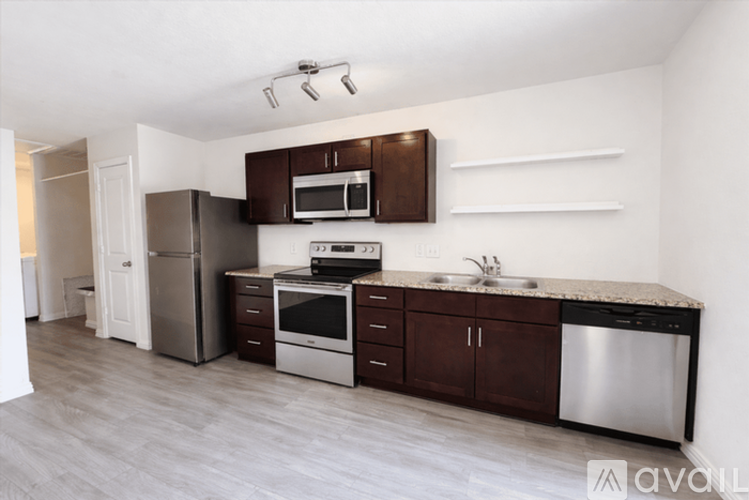 A kitchen with brown cabinets and stainless steel appliances.
