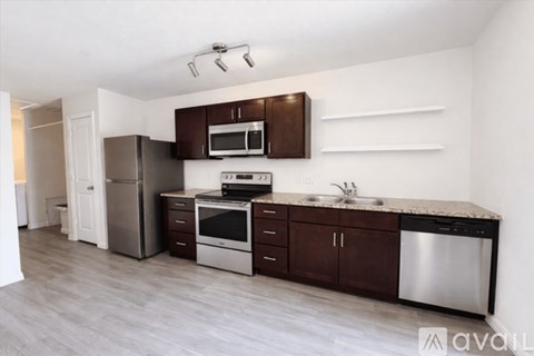 A kitchen with brown cabinets and stainless steel appliances.