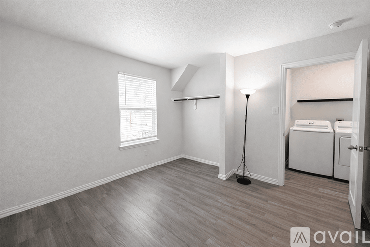 A room with a window, a lamp, and a washing machine.