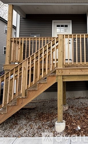 A wooden staircase leading to a white door.