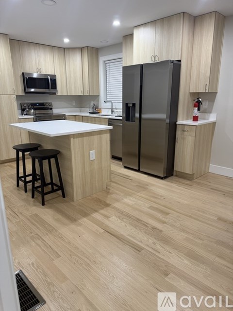 A kitchen with wooden floors and a white counter.
