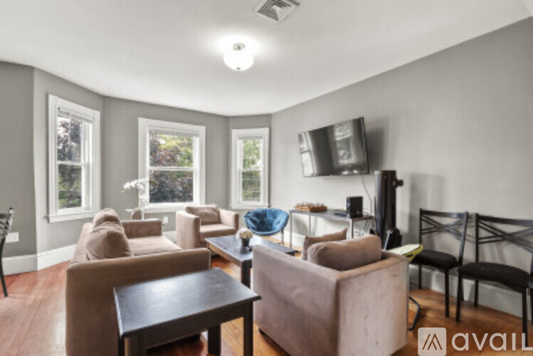 A living room with a television, chairs, and a dining table.