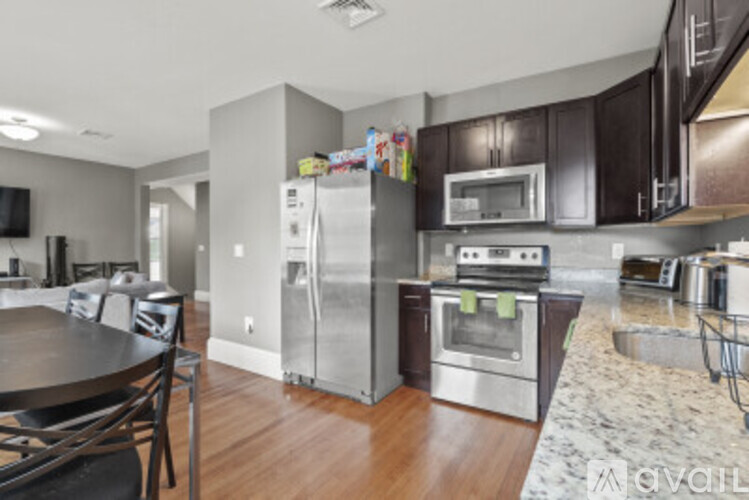 A kitchen with a table and chairs and a refrigerator.