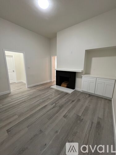 A room with a fireplace and wooden flooring.