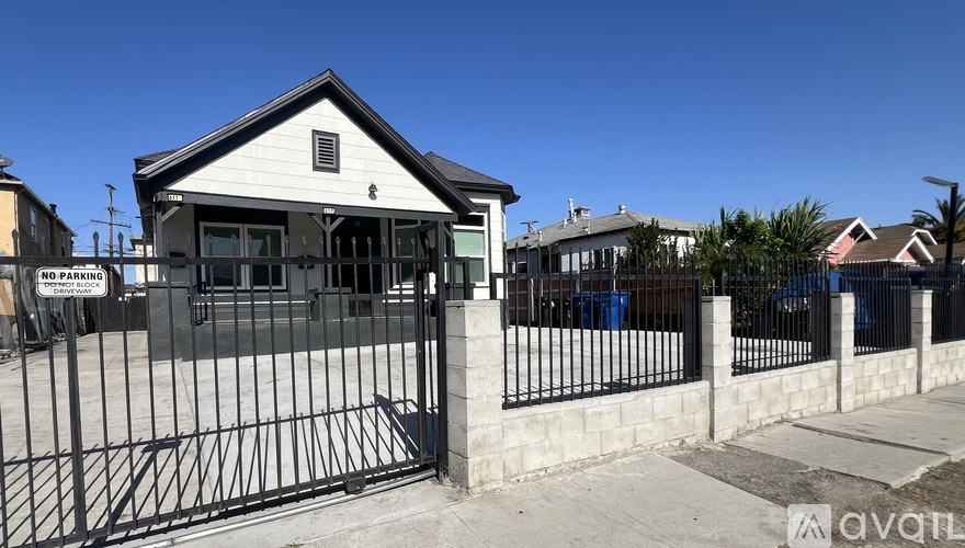 A small building with a black gate in front of it.